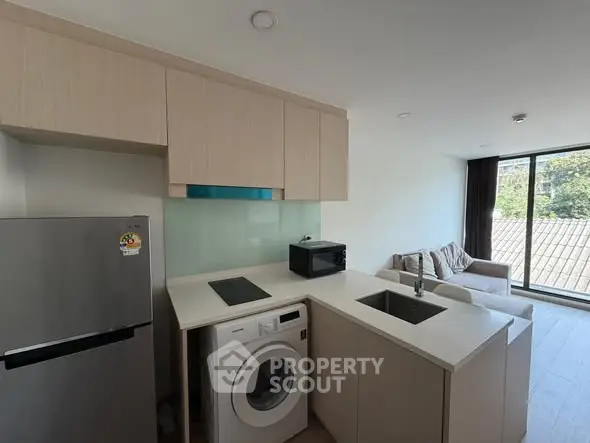 Modern kitchen with washing machine and open layout in bright apartment