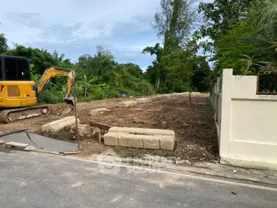 Vacant land plot with construction equipment, ideal for new development in a serene location.