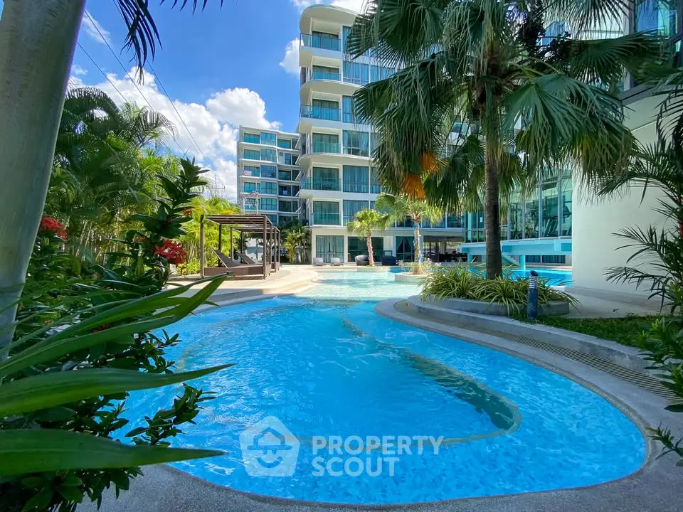 Luxurious modern apartment complex with stunning pool and lush greenery.