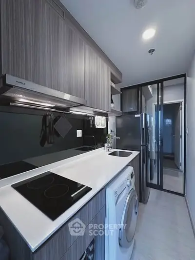 Modern kitchen with sleek cabinetry and built-in appliances in a compact layout.