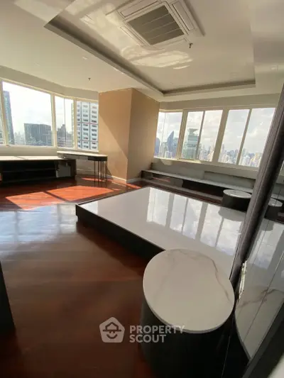 Spacious modern living room with panoramic city views and elegant wood flooring.