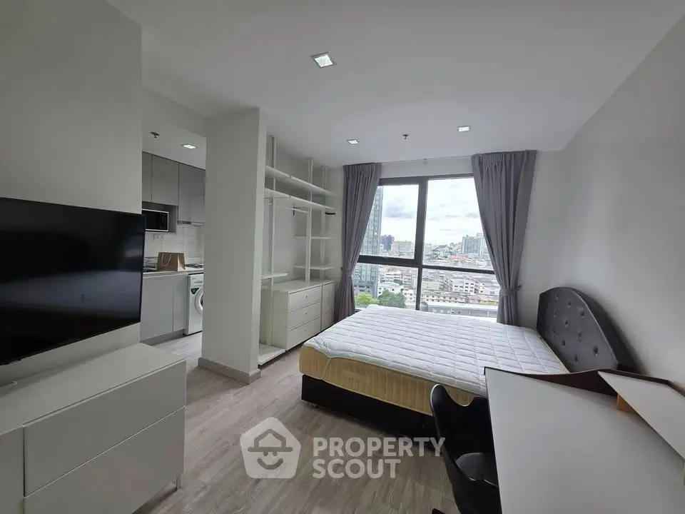 Modern bedroom with city view, featuring sleek furniture and ample natural light.