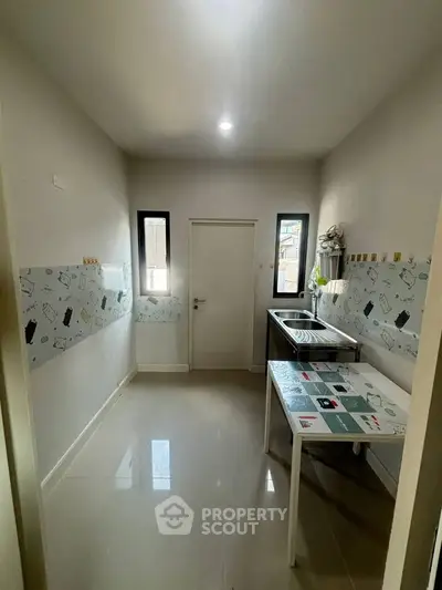 Modern kitchen with sleek design and ample natural light, featuring a compact layout and stylish decor.