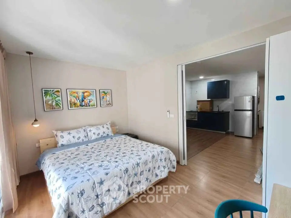 Modern bedroom with cozy decor and open kitchen layout in stylish apartment.