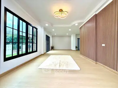Spacious modern living room with elegant lighting and large windows.