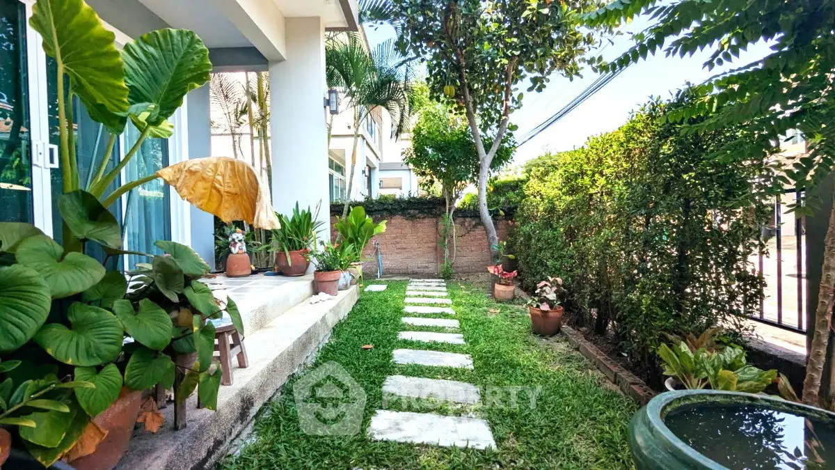 Charming garden with lush greenery and stepping stones in a serene residential setting.