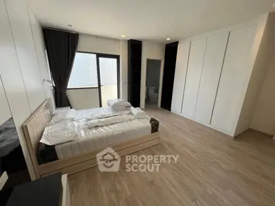 Spacious modern bedroom with large windows and ample storage space.