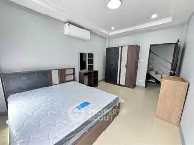 Spacious modern bedroom with sleek furniture and air conditioning in a stylish home.