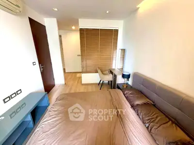 Modern bedroom with stylish decor and natural light, featuring a cozy bed and elegant furnishings.