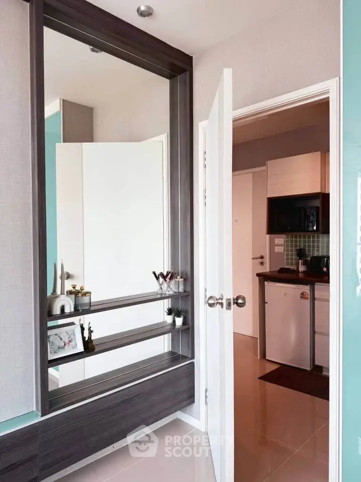 Modern apartment entrance with stylish decor and compact kitchen view