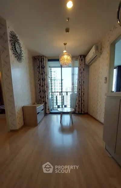 Spacious living room with elegant chandelier and balcony view in modern apartment