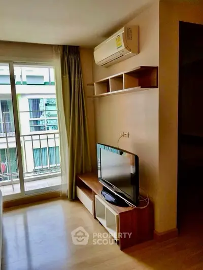 Modern living room with air conditioning and TV, featuring a balcony view.
