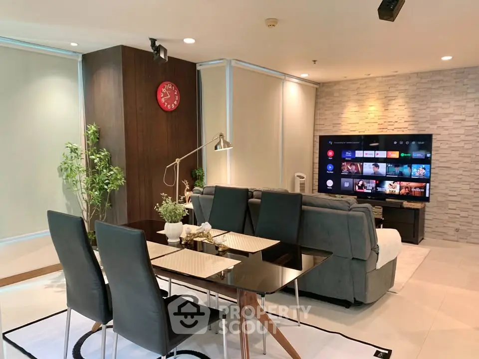 Modern living room with dining area, stylish decor, and large TV setup, perfect for entertainment and relaxation.