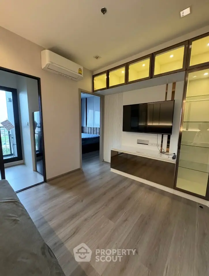 Modern living room with sleek TV setup and balcony view
