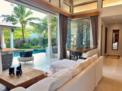 Luxurious open-plan living room with pool view and tropical garden, featuring elegant decor and high ceilings.