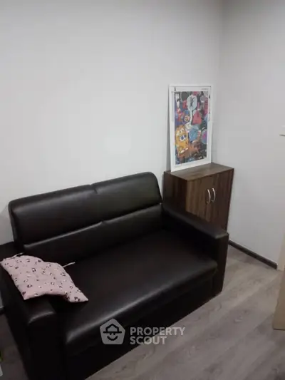 Cozy small living room with black leather sofa and modern decor