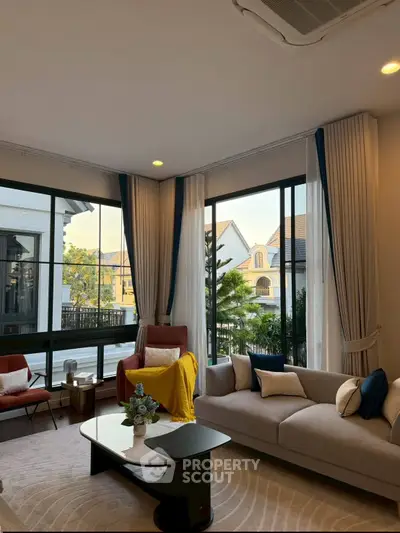 Elegant living room with large windows and stylish furniture in a modern home.