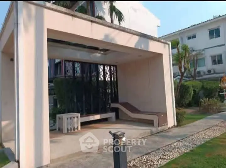 Modern residential building with stylish outdoor seating area and lush greenery