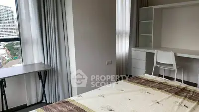 Modern bedroom with study area and large windows offering city views