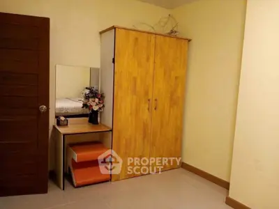 Cozy bedroom with wooden wardrobe and vanity table, ideal for modern living.