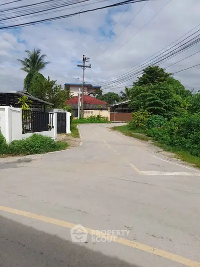 Charming suburban street view with lush greenery and residential homes, perfect for peaceful living.