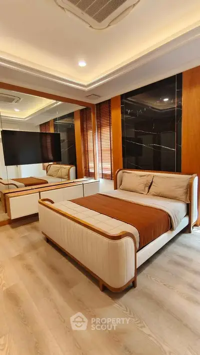 Luxurious modern bedroom with elegant decor and mirrored wall, featuring a stylish bed and ambient lighting.