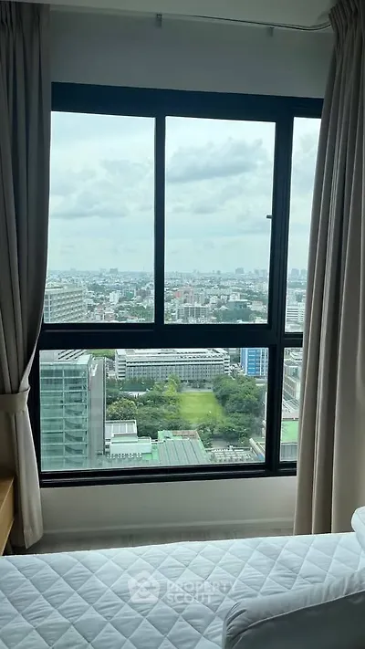 Stunning city view from a high-rise bedroom window, offering a serene and expansive urban landscape.