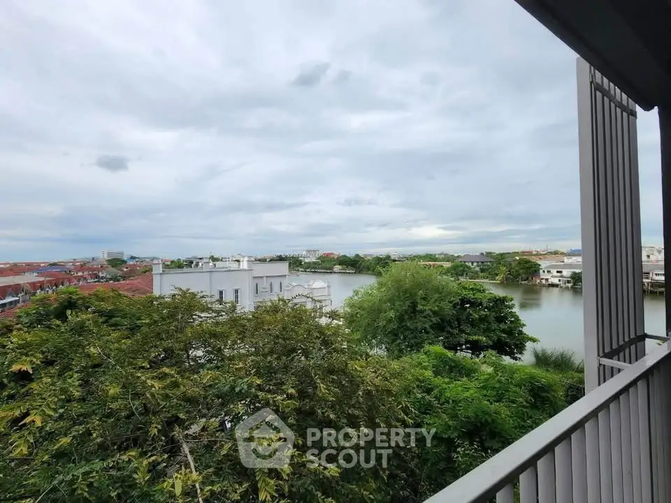 Stunning balcony view overlooking serene lake and lush greenery in modern residential area.