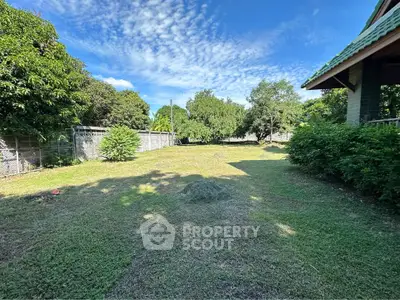 Spacious backyard with lush greenery and clear blue sky, perfect for outdoor activities and relaxation.