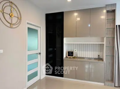 Modern interior with sleek cabinetry and stylish wall clock in a contemporary living space.