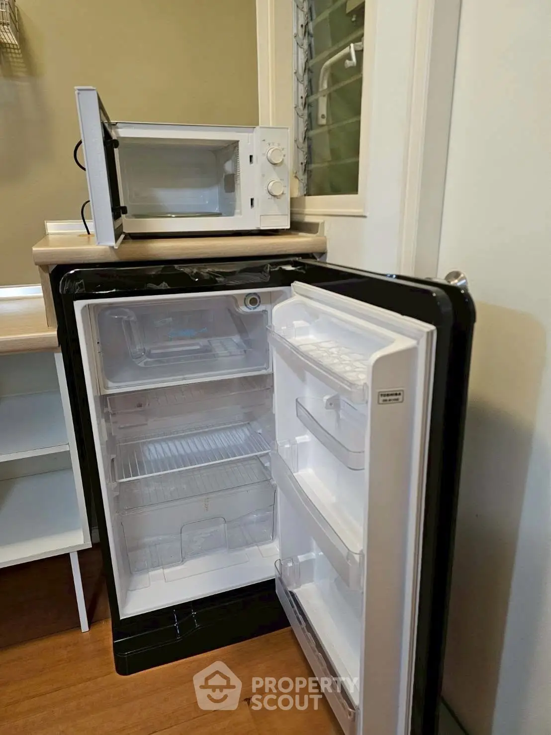 Compact kitchen area with mini fridge and microwave, ideal for small apartments or studios.