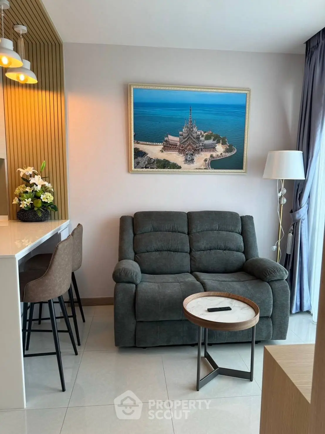 Modern living room with cozy sofa, stylish decor, and ocean-themed artwork, perfect for relaxation.