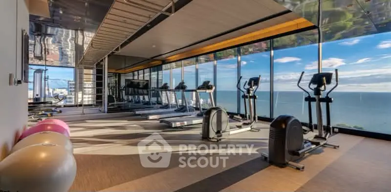 Luxurious gym with panoramic ocean views and modern fitness equipment.