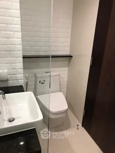 Modern bathroom with sleek design featuring white tiles and contemporary fixtures.