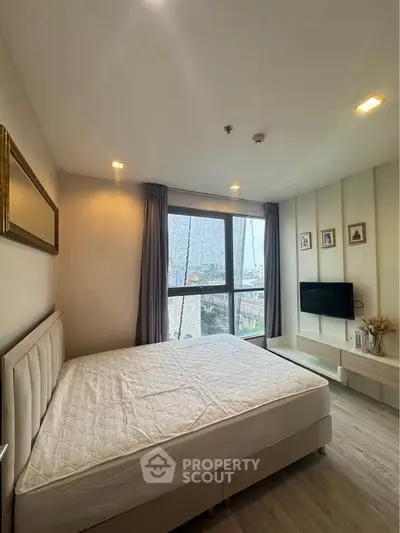 Modern bedroom with large window and stylish decor in a high-rise apartment.
