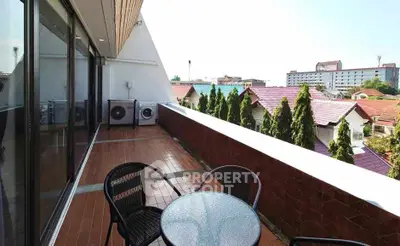 Spacious balcony with outdoor seating and city view, perfect for relaxation.