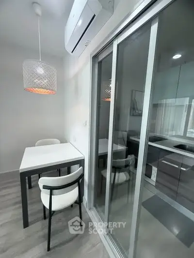 Modern kitchen with sleek design and sliding glass doors, featuring a dining table and chairs.