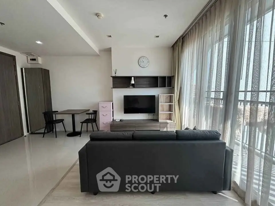 Modern living room with sleek furniture and large windows offering abundant natural light.