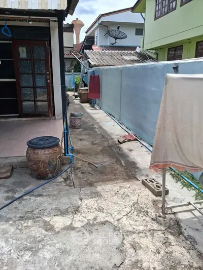 Charming outdoor space with rustic elements and potential for renovation in a residential area.