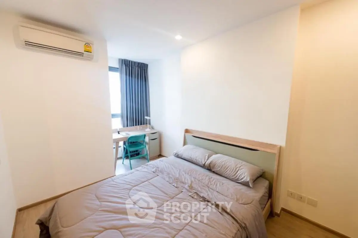 Modern bedroom with cozy bed and study area, featuring natural light and minimalist design.