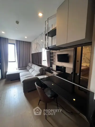 Modern living room with sleek design, featuring a comfortable sectional sofa and wall-mounted TV, perfect for relaxation.