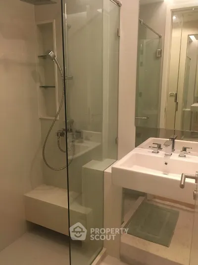 Modern bathroom with glass shower and sleek fixtures in a contemporary home.