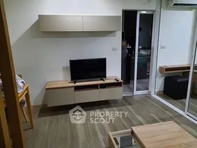 Modern living room with sleek furniture and wall-mounted TV in a cozy apartment.