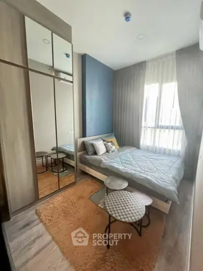 Modern bedroom with stylish decor and large mirrored wardrobe