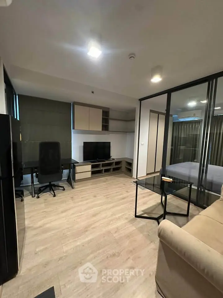 Modern living room with sleek furniture and glass partition in stylish apartment.