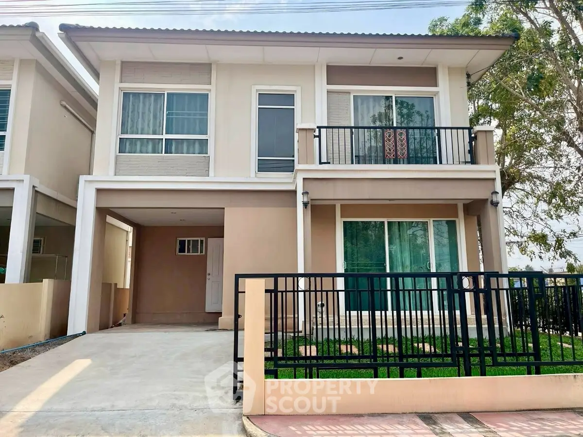 Modern two-story house with balcony and driveway in a suburban neighborhood.