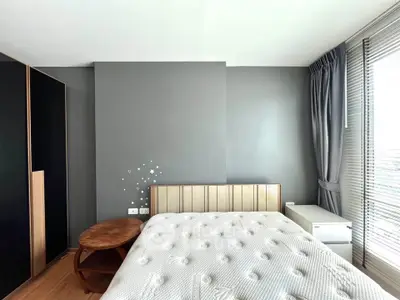 Modern bedroom with stylish decor and natural light, featuring a comfortable bed and sleek furniture.