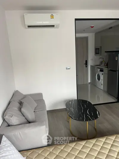 Modern apartment interior with cozy living area and sleek kitchen appliances.