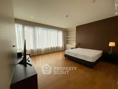 Spacious bedroom with large windows and modern furnishings