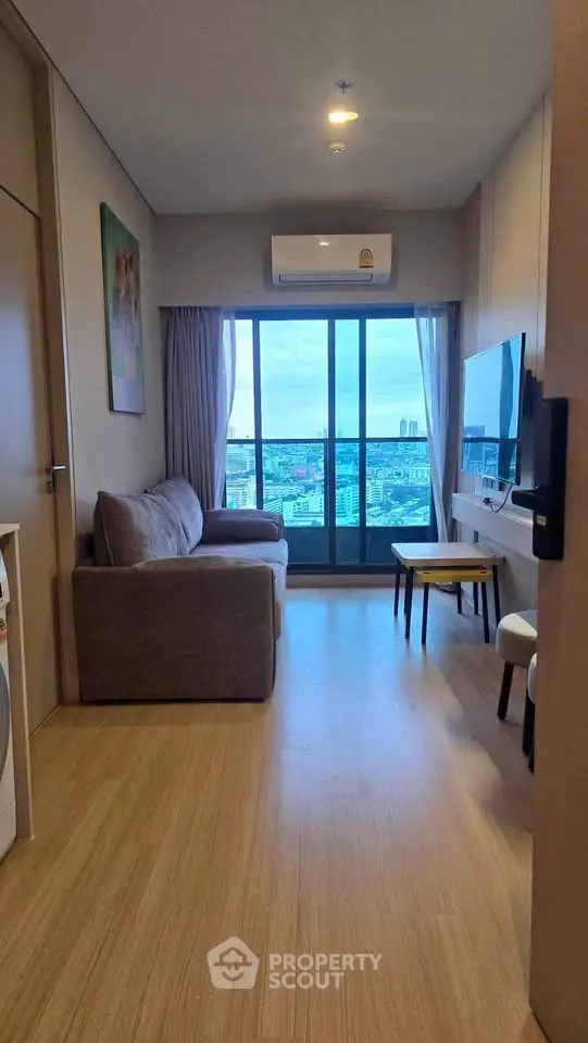 Modern living room with city view, featuring cozy sofa and wall-mounted TV.